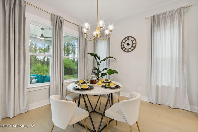 dining space with a notable chandelier and light hardwood / wood-style flooring