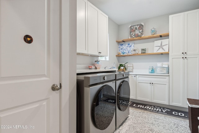 laundry area featuring washing machine and dryer and cabinets