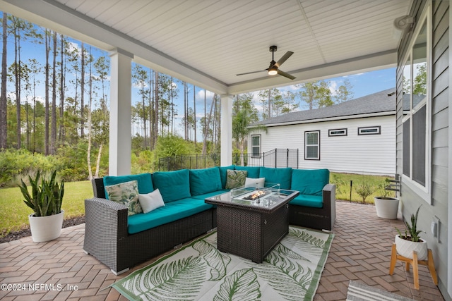 view of patio / terrace featuring ceiling fan and an outdoor living space with a fire pit