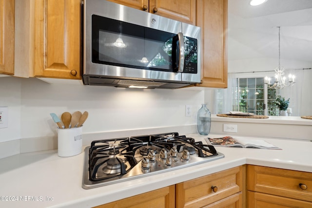 kitchen with appliances with stainless steel finishes and a chandelier