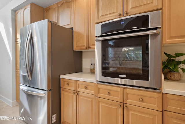 kitchen with light brown cabinets and stainless steel fridge