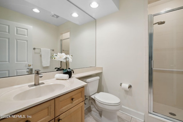 bathroom with vanity, a shower with shower door, toilet, and tile patterned floors