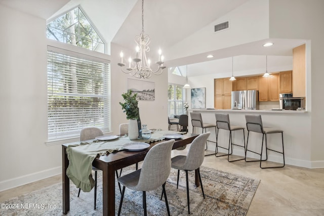 dining area featuring high vaulted ceiling, a chandelier, and plenty of natural light