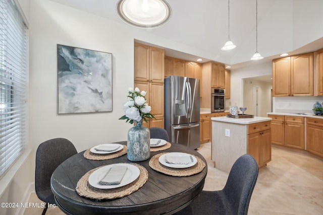 kitchen featuring appliances with stainless steel finishes, lofted ceiling, a center island, and pendant lighting