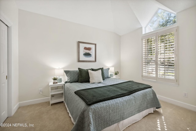 carpeted bedroom featuring a closet and vaulted ceiling