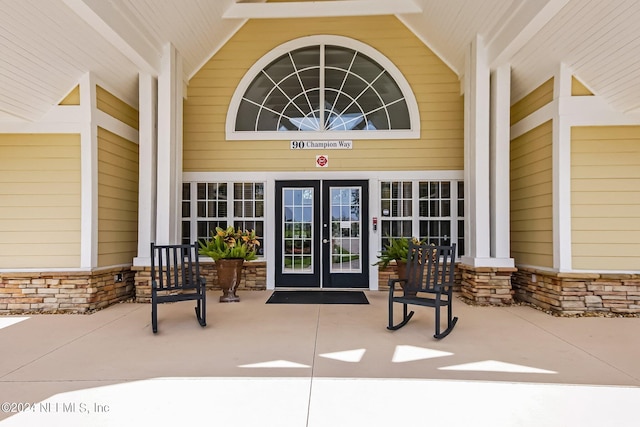 view of exterior entry featuring a porch and french doors