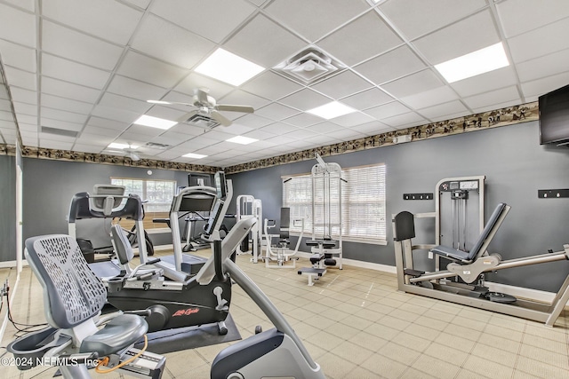 workout area featuring ceiling fan and a paneled ceiling