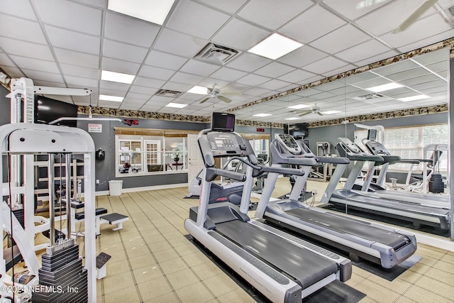 exercise room with a drop ceiling and ceiling fan