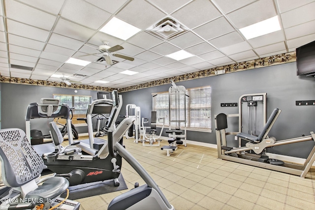 exercise room with a paneled ceiling and ceiling fan