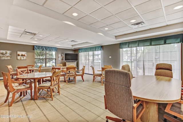 dining space featuring a drop ceiling, a raised ceiling, and crown molding