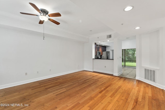 unfurnished living room with light hardwood / wood-style floors, ornamental molding, and ceiling fan