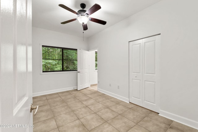 unfurnished bedroom with ceiling fan, a closet, and light tile patterned floors