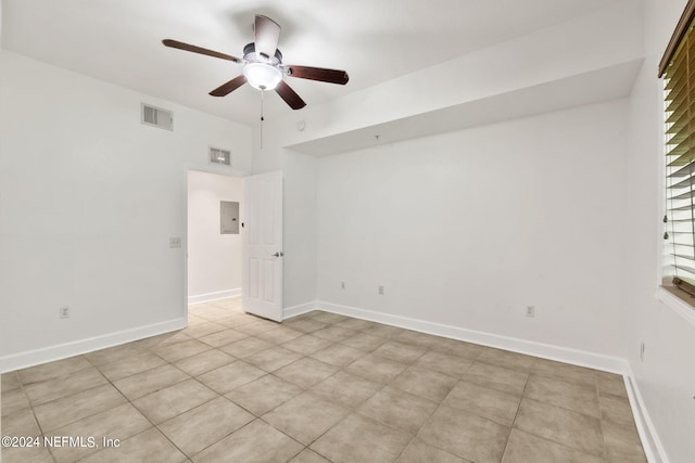 unfurnished room with ceiling fan, electric panel, and light tile patterned floors