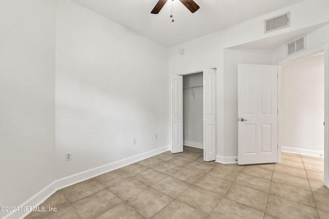 unfurnished bedroom featuring light tile patterned flooring, ceiling fan, and a closet