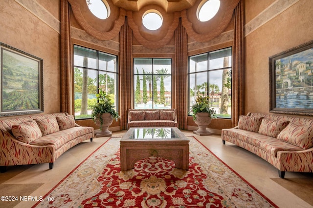 living room with a high ceiling and plenty of natural light