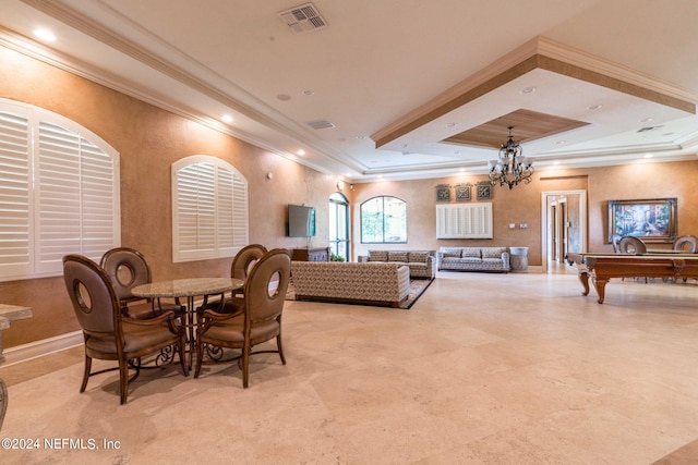 dining area featuring a raised ceiling, a chandelier, and ornamental molding