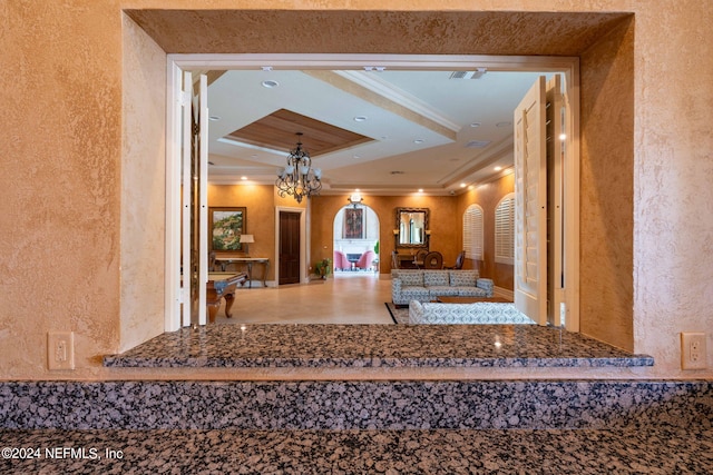 hallway featuring ornamental molding and an inviting chandelier