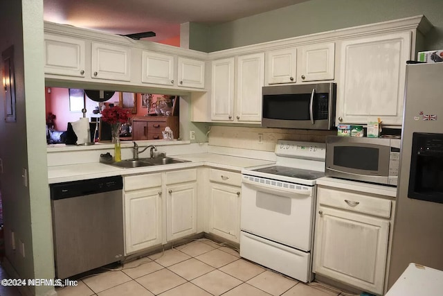 kitchen featuring appliances with stainless steel finishes, light tile patterned flooring, and sink