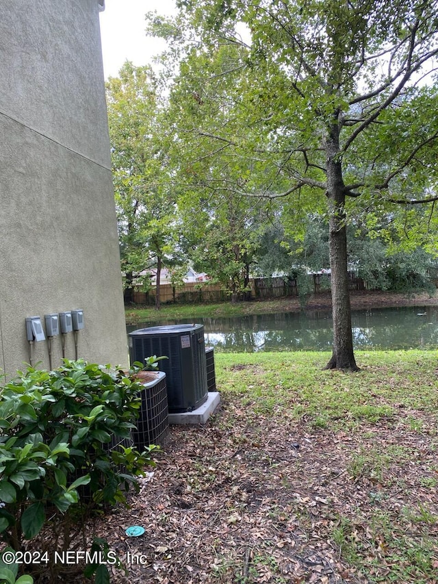 view of yard with central AC unit and a water view