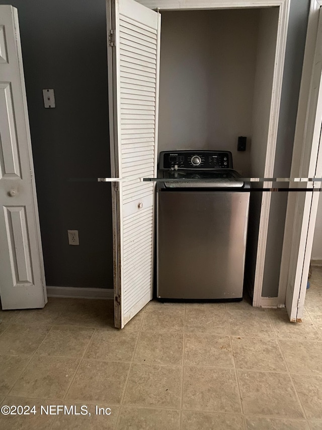 washroom featuring washer / clothes dryer and light tile patterned floors