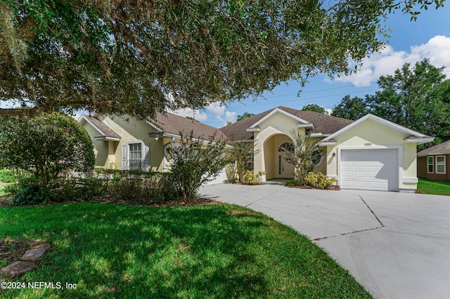 ranch-style house with a garage and a front lawn