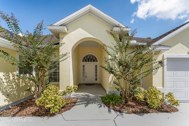 view of exterior entry with a garage