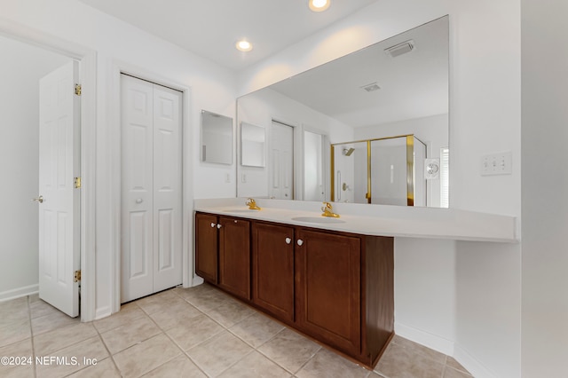 bathroom with tile patterned flooring, vanity, and a shower with door