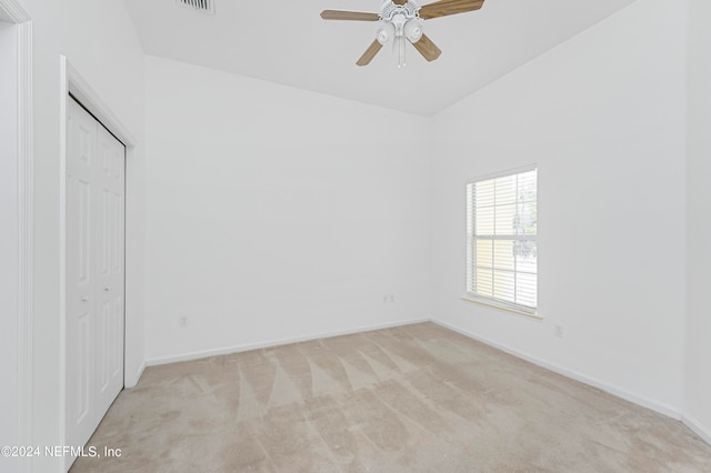 unfurnished bedroom with a closet, ceiling fan, and light colored carpet