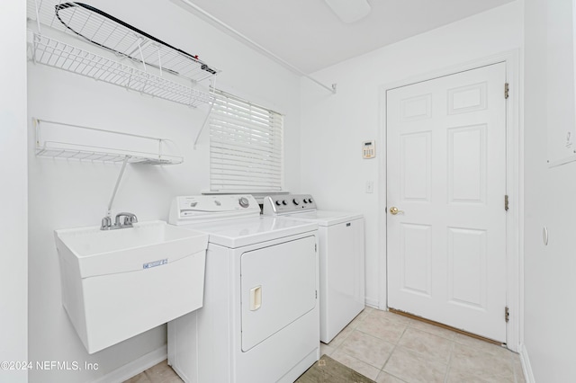 clothes washing area featuring independent washer and dryer, light tile patterned floors, and sink