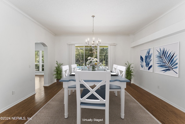 dining area with a notable chandelier, dark hardwood / wood-style flooring, ornamental molding, and a textured ceiling