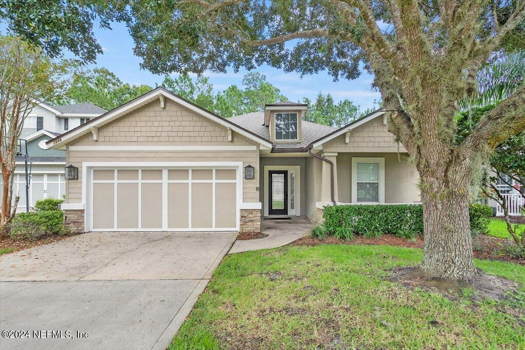 craftsman house featuring a garage and a front yard