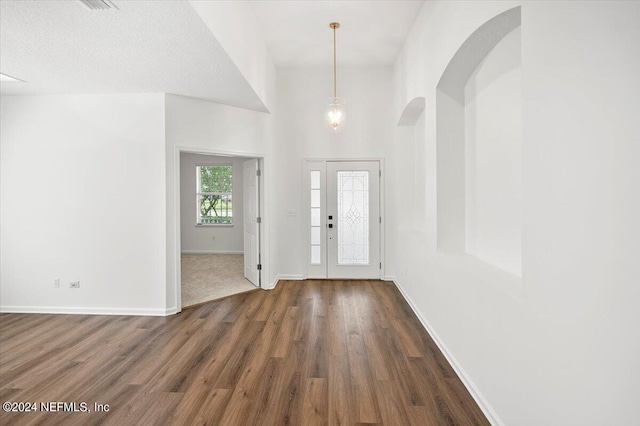 foyer entrance with a textured ceiling and dark hardwood / wood-style floors