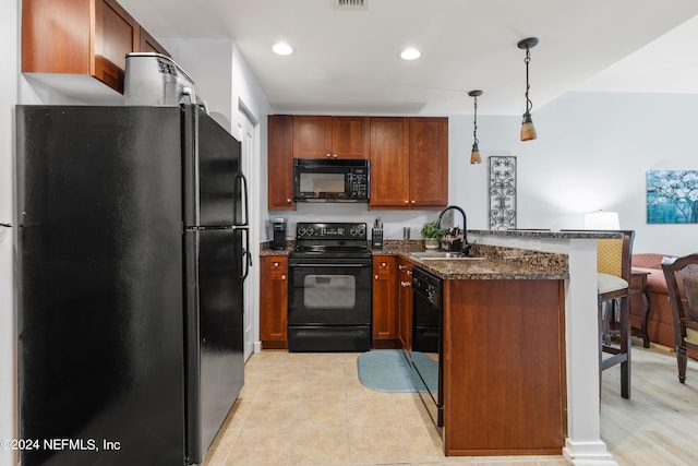 kitchen featuring dark stone countertops, kitchen peninsula, pendant lighting, black appliances, and sink