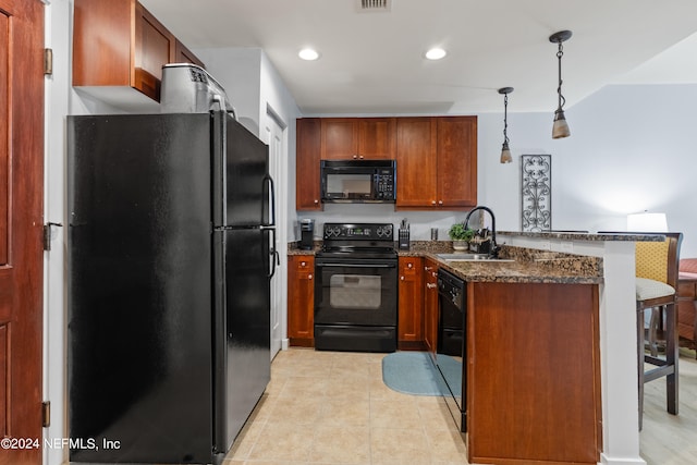 kitchen with dark stone counters, sink, kitchen peninsula, hanging light fixtures, and black appliances