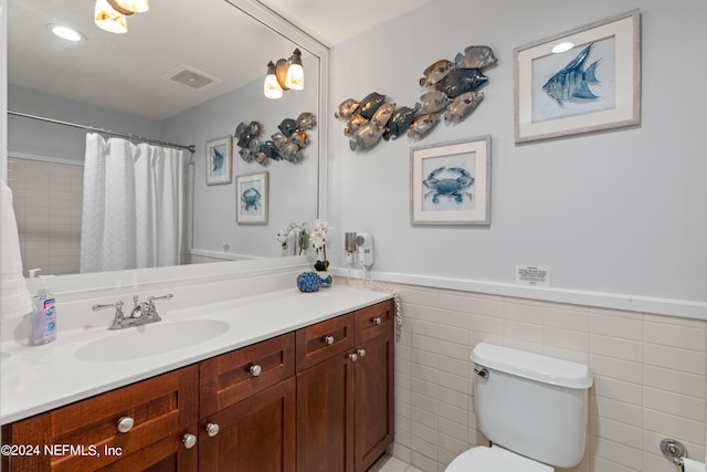 bathroom with walk in shower, tile walls, vanity, and toilet