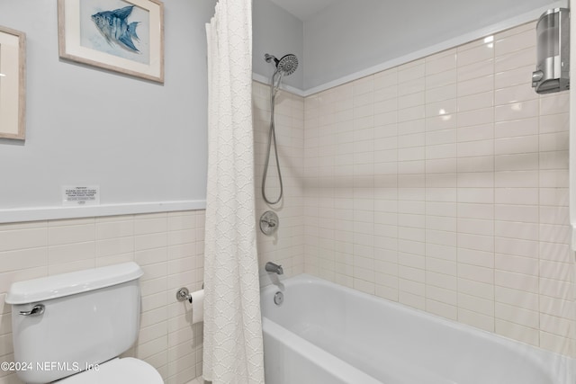 bathroom with tile walls, toilet, and shower / bathtub combination with curtain