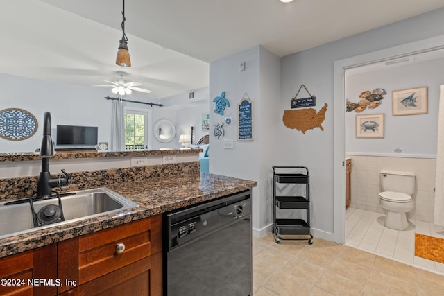 kitchen featuring light tile patterned floors, sink, decorative light fixtures, dishwasher, and tile walls