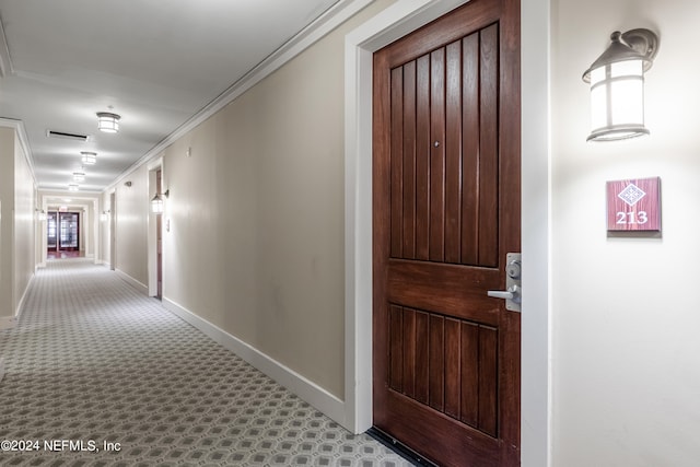 hall featuring crown molding and light carpet