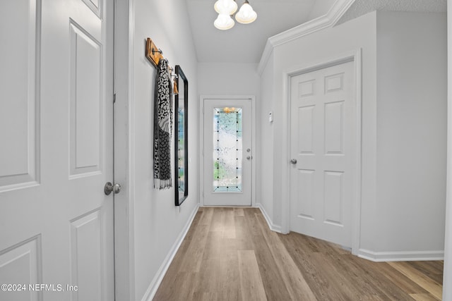 entryway with a textured ceiling, crown molding, and light hardwood / wood-style floors