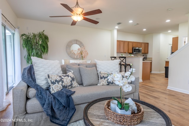 living room with light wood-type flooring and ceiling fan