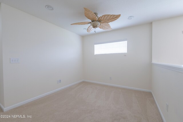 carpeted empty room featuring ceiling fan