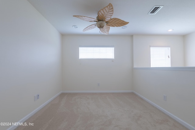 carpeted empty room featuring ceiling fan and plenty of natural light