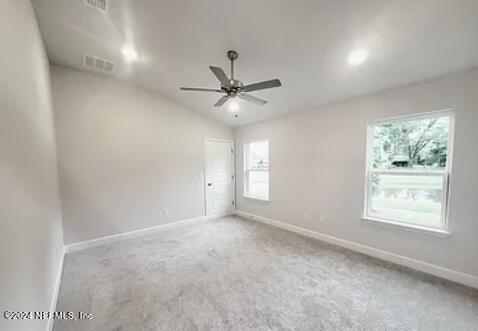 carpeted spare room with vaulted ceiling and ceiling fan