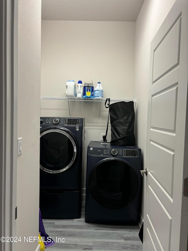 washroom featuring independent washer and dryer and light hardwood / wood-style flooring