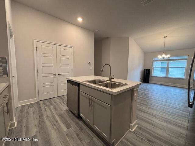 kitchen with dishwasher, an island with sink, sink, hanging light fixtures, and gray cabinets