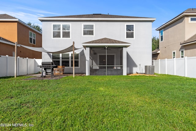 back of house with a lawn, a sunroom, ceiling fan, central AC, and a patio