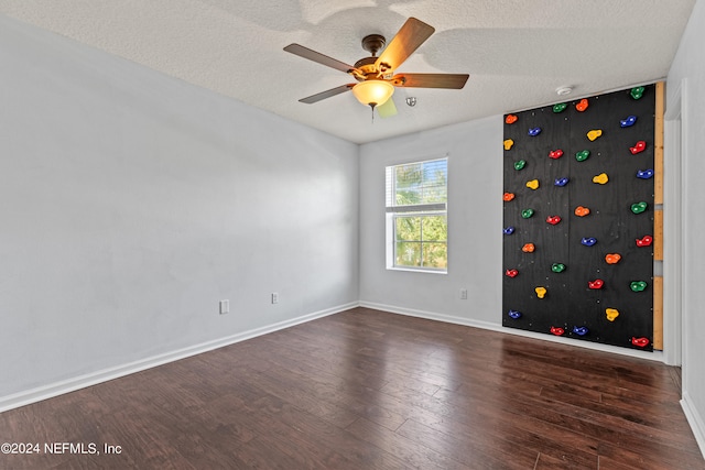 unfurnished room featuring ceiling fan, dark hardwood / wood-style floors, and a textured ceiling