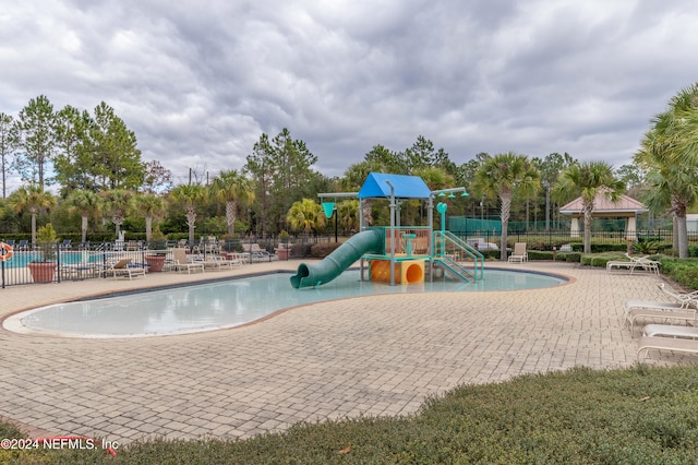 view of jungle gym with a community pool and a patio