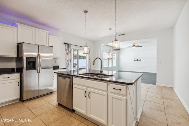 kitchen featuring sink, ceiling fan, a textured ceiling, appliances with stainless steel finishes, and an island with sink