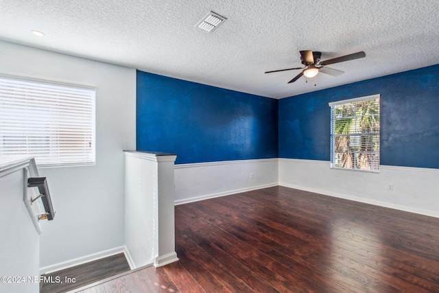 empty room featuring ceiling fan, dark hardwood / wood-style flooring, and a textured ceiling